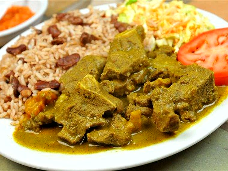 Curry goat with rice and peas, tomato and salad
