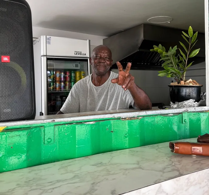 The Jamaican cook at the serving window of Reggae Vibes Takeaway