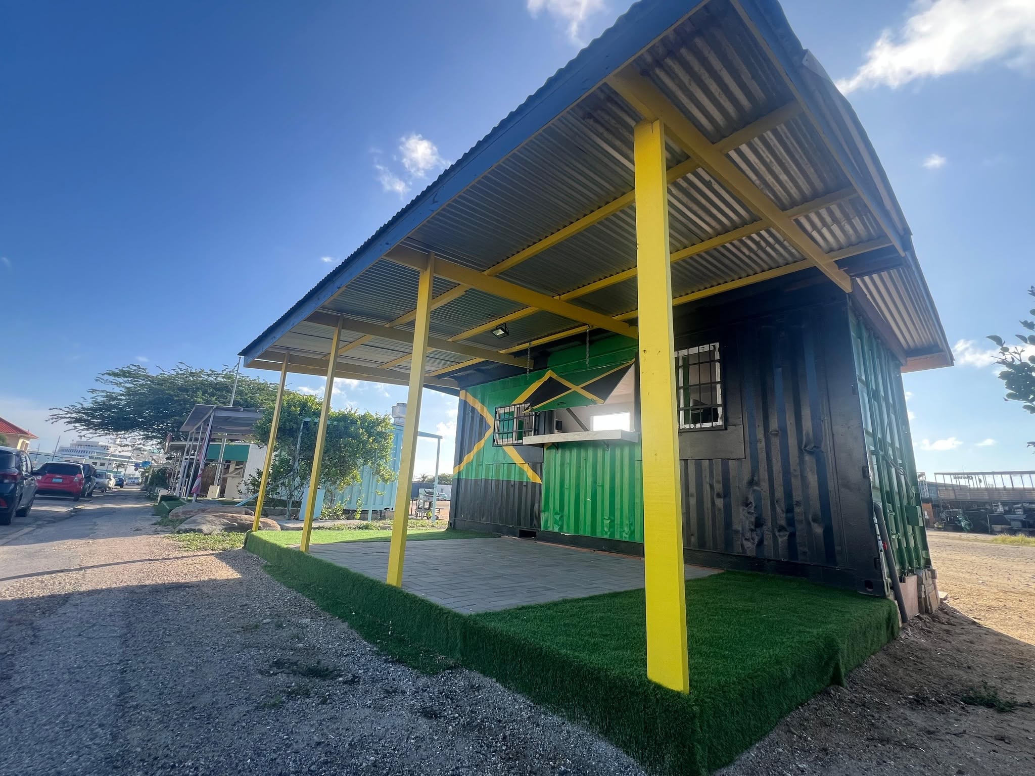 The stand from the street with its yellow posts and covered terrace